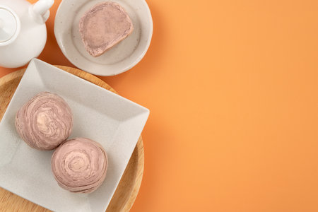 Taro puff pastries for Mid Autumn Festival holiday afternoon tea on orange table background.の写真素材