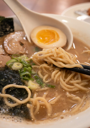 Rich tonkotsu ramen with char siu, soft-boiled egg, and seaweed in a savory broth.の写真素材