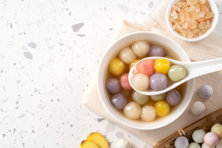 Traditional Asian sweet soup with colorful glutinous rice balls tangyuan served in warm sweet ginger...