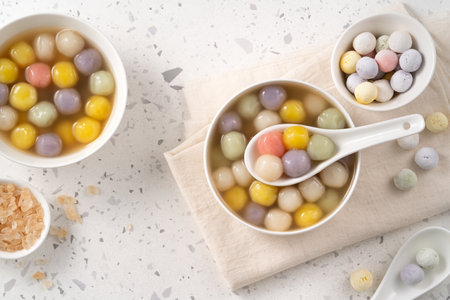 Traditional Asian sweet soup with colorful glutinous rice balls tangyuan served in warm sweet ginger...
