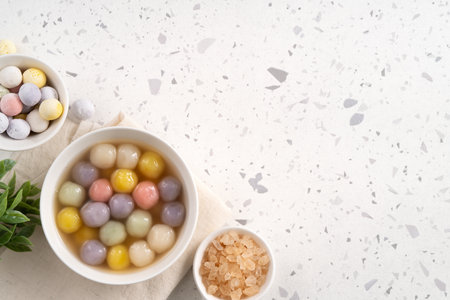 Traditional Asian sweet soup with colorful glutinous rice balls tangyuan served in warm sweet ginger syrup in white backgroundの写真素材