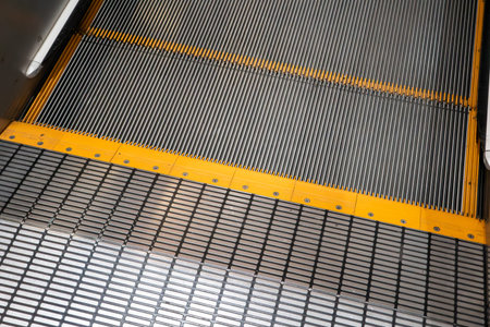 A clean metal escalator viewed from below, showing repeating steps in a modern interior.