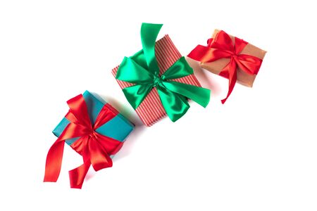 Bright christmas gifts with colorful atlas ribbons isolated on whiteの写真素材