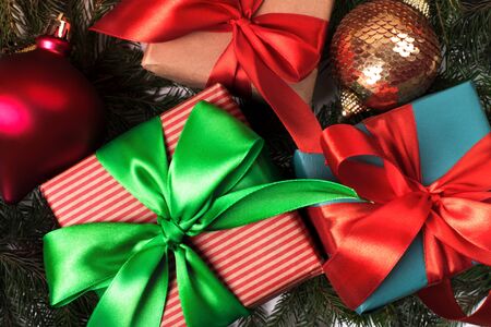 Bright christmas gifts with colorful atlas ribbons isolated on whiteの写真素材