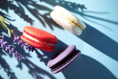 Cakes macaroon or macaron on blue background, close up