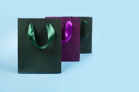 Gift or present paper bags with atlas ribbon, colorful, no logo, on blue backgroundの写真素材