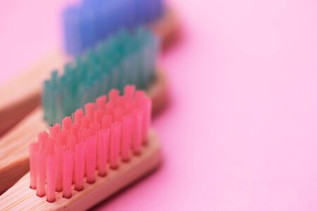 Colorful bamboo brushes on pink background, ecology products concept