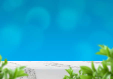 Empty marble table with leaves and blue bokeh background for product backdrop with copy space for...
