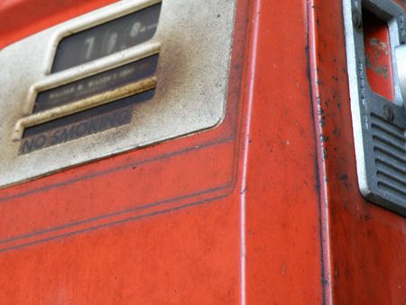 An old red gas pump with corroded and oxidized metal appearing through the original paint. の写真素材