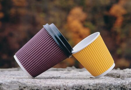Concept of reliance, friendship, support, relations, male female, A pair of brown yellow paper cups, take out, coffee to go. Two eco-friendly heat proof cardboard mugs, close upの写真素材