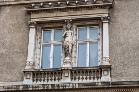 Vintage window with decorative elements and sculptures in old european historical buildingの写真素材