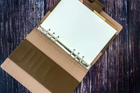 An open blank planner, spiral binders with leather cover and colorful tabs index, isolated on white background.の写真素材