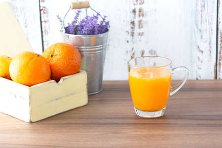 Glass of orange juice lay on wood tableの写真素材