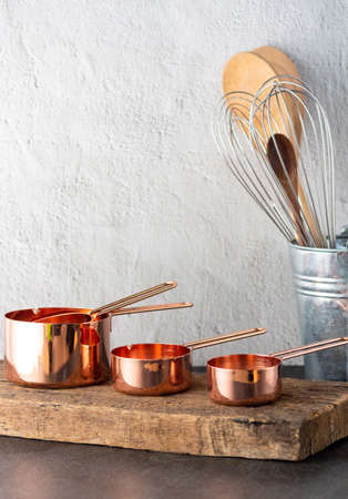 Vintage set of measuring spoons and baking utensils for traditional kitchen style with old retro wooden boardの写真素材