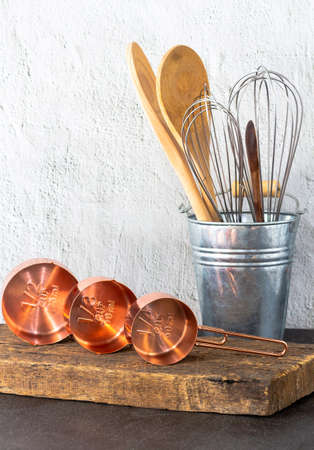 Vintage set of measuring spoons and baking utensils for traditional kitchen style with old retro wooden boardの写真素材