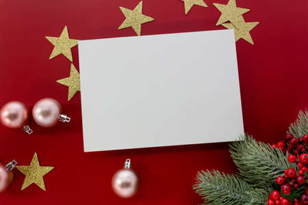 Christmas mockup, glittering stars and ornaments with blank card for copy space on red background.