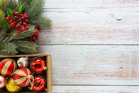 Christmas background, red ornaments and pine leaves on wooden table top for festive decoration.の写真素材