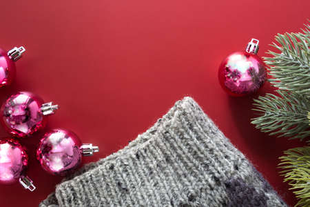 Christmas background, gray sweater and sweet pink balls ornaments on red backgroundの写真素材