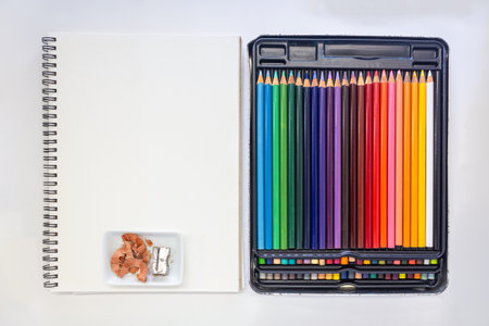 Minimalist desk arrangement featuring a professional set of multicolored pencils in a black case...