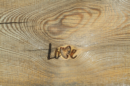 Love. Romantic card with natural background. Natural hole in the wooden texture looks as heart.の写真素材
