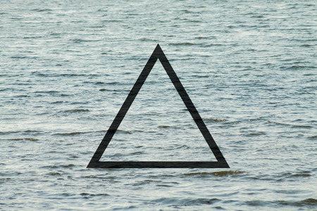 Black flat triangle on abstract water background. Abstract psychedelic background.の写真素材