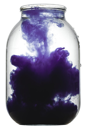 Paint swirling in water. Splashes of paint in a glass jar.の写真素材