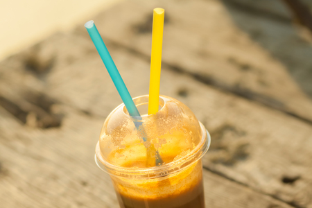Fresh juice in a plastic cup with two strawsの写真素材