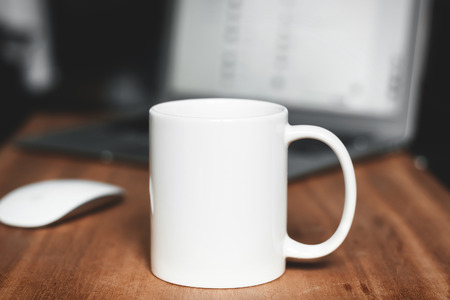 White mug on the desktopの写真素材