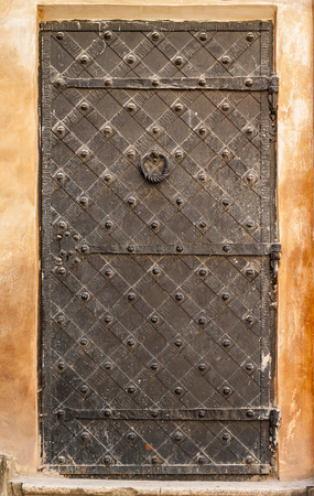 Iron door with door knocker. Exterior design element of ancient Lvov. Example of world architectural heritage.の写真素材