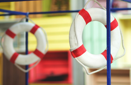 Lifebuoys on the background of multi-colored wooden boxesの写真素材