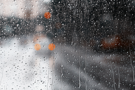 Raindrops on glass. Blurry backdrop. Rainy traffic. View from wet window.の写真素材