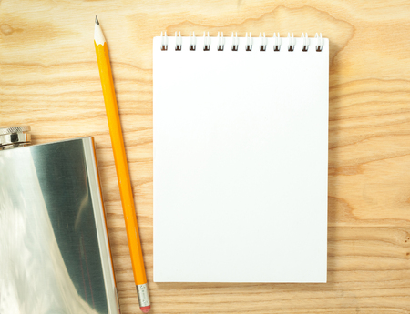 Top view of open spiral blank notebook and steel flask on wood desk backgroundの写真素材