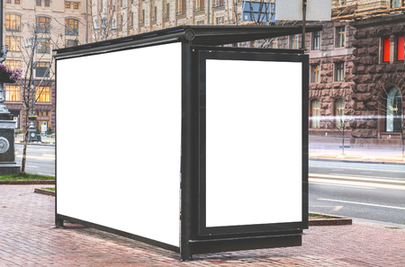 Vertical blank glowing billboard on the bus stop. Street outdoor advertising.の写真素材
