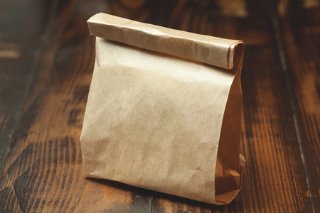 Little paper bag on wooden backgroundの写真素材