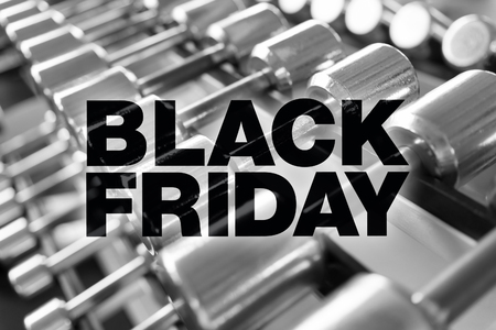 Black friday poster. Rows of dumbbells in the gym with high contrast lightの写真素材