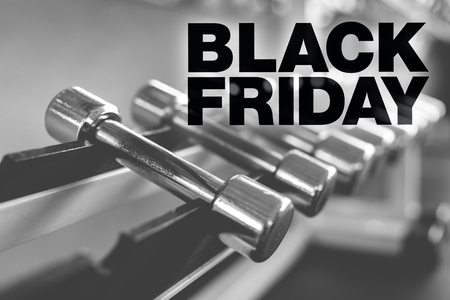 Black friday poster. Rows of dumbbells in the gym with high contrast lightの写真素材