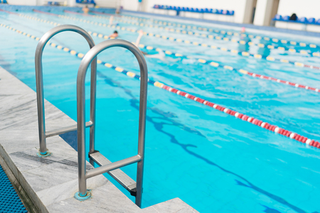 Swimming pool handrails. Clear blue water on background.の写真素材