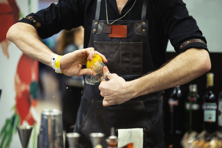 Bartender rubs a glass with lemon. Making a cocktailの写真素材