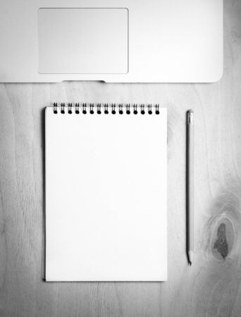 Business essentials. Top view of spiral blank notebook and laptop on wood desk backgroundの写真素材