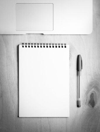 Business essentials. Top view of spiral blank notebook and laptop on wood desk backgroundの写真素材
