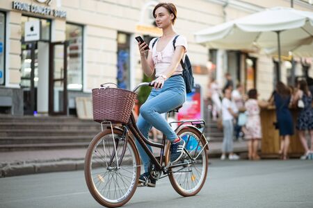 Kyiv, Ukraine, June 13, 2019. Girl with smartphone ride a bicycle on Sagaydachnogo streetのeditorial素材