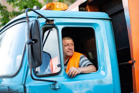 Kyiv, Ukraine, may 26, 2019. Garbage truck driver smokes in the truck cabのeditorial素材