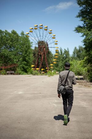 Pripyat, Ukraine, May 20, 2019. Man goes to the ferris wheel in Pripyat amusement parkのeditorial素材