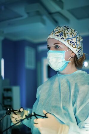 Surgeon woman doing surgical operation with laparoscopic instrumentsの写真素材