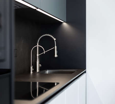 Modern kitchen washbasin with chrome faucet (water mixer) close-up.の写真素材