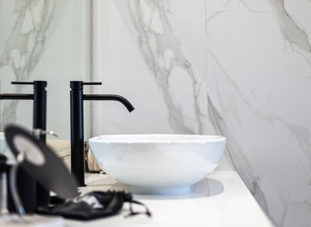 Modern white washbasin with black faucetの写真素材