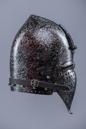 Medieval Knight Helmet with Visor. Polished metal head protection with ventilation holes and a hinged face guard.の写真素材
