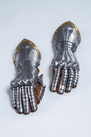 Pair of steel knight gauntlets with golden accents. Detailed metallic hand protection gloves, part...