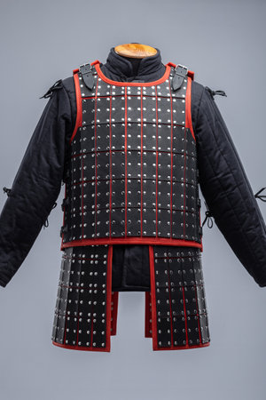Black Leather Samurai Armor with Red Trim. Traditional Japanese warrior garment featuring layered leather plates and vibrant red accents.の写真素材