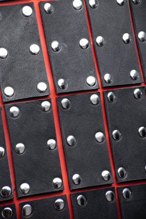 Close-Up Detail of Black Leather Samurai Armor Plates. Detailed texture of layered leather pieces with metal stud accents, forming a traditional Japanese defense.の写真素材